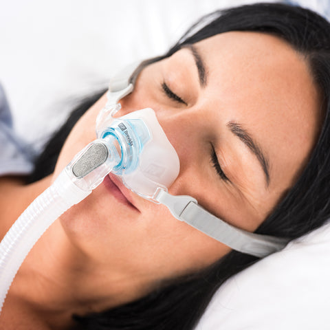 Woman in bed wear brevida nasal pillow mask